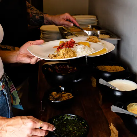 Cliente servindo acompanhamentos no buffet da casa