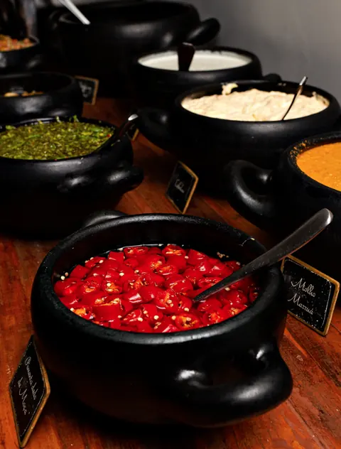 Vinagrete, chimichurri e molhos em panelinhas de ferro no buffet