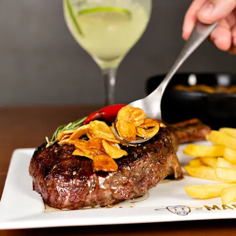 Medalhão de carne com chips de alho, fritas e drink de limão
